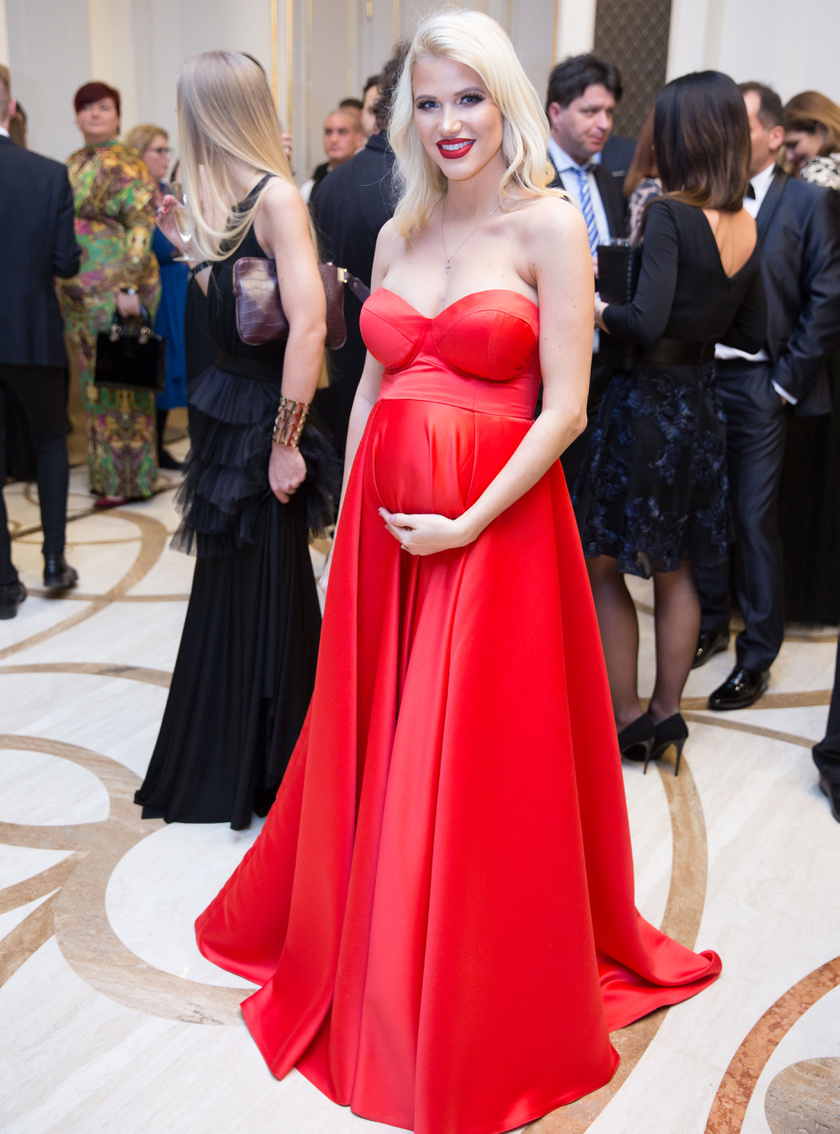 Vasvári Vivien már a terhesség utolsó trimeszterébe lépett. A kismama babapocakja szépen gömbölyödik a Bernice Fashion tűzpiros estélyi ruhájában.