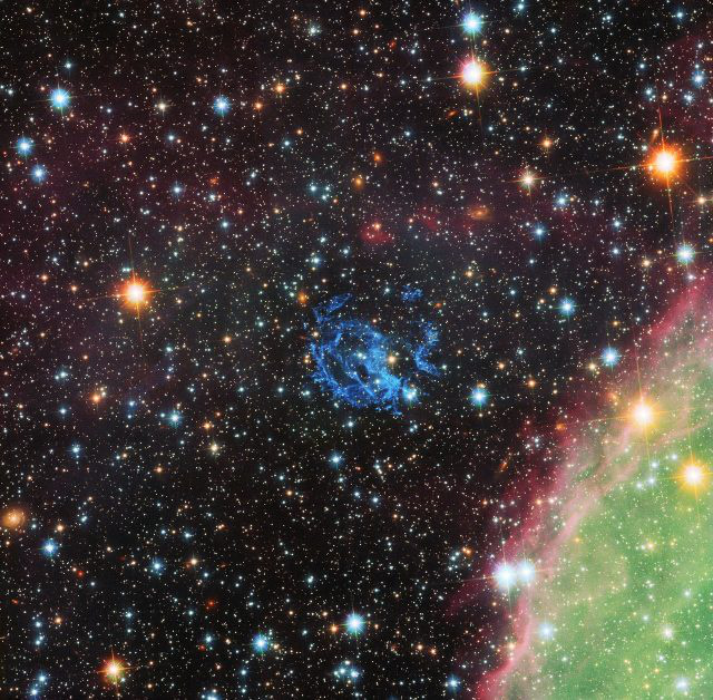 A NASA/ESA Hubble-űrtávcsöve által készített képen az 1E 0102.2-7219 jelű szupernóva-maradványt alkotó csomók kék színben láthatók a kép közepének közelében. A kép jobb alsó sarkában zöldben és rózsaszínben az N 76 vagy Henize 1956 katalógusjelű hatalmas csillagkeletkezési terület egy része is megfigyelhető.