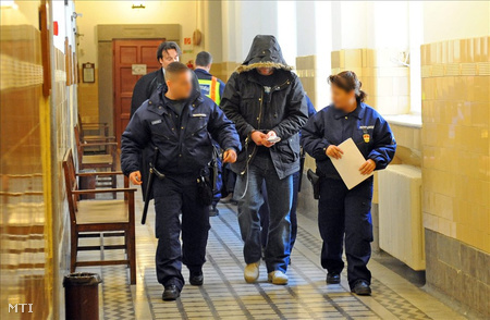 Rendőrök bilincsben vezetik azt a sorozatrablót, aki 2011. március 9-én kirabolt egy XI. kerületi Villányi úti bankot.