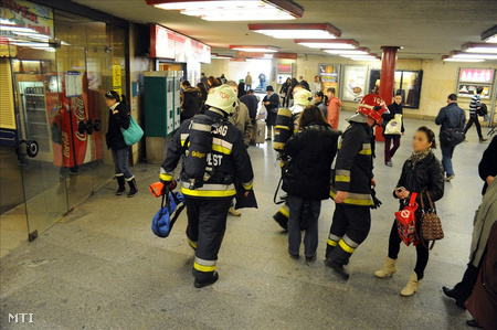 Tűzoltók mennek a várakozó emberek között a Nyugati pályaudvar aluljárójában