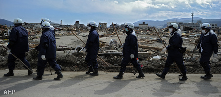 Japán mentők sétálnak a romok között Rikuzentakatában, Ivate prefektúrában