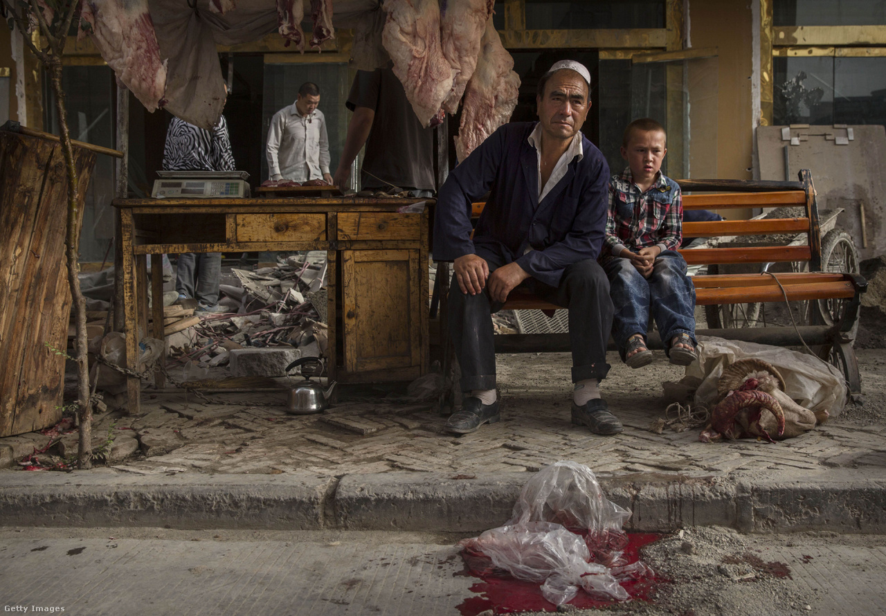 Egy ujgur hentes a fiával várja a vásárlókat