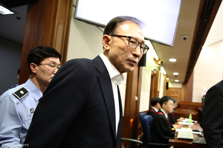 A többek között korrupcióval és hatalommal való visszaéléssel vádolt volt dél-koreai elnök egy szöuli bíróság tárgyalótermébe érkezik 2018. május 23-án.