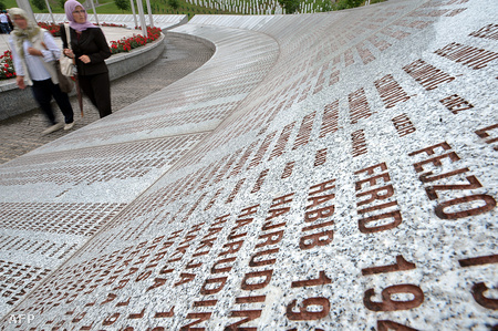 Boszniai muszlim nők sétálnak a szrebrenicai áldozatok emlékére létrehozott emlékmű mellett, Szrebrenica közelében