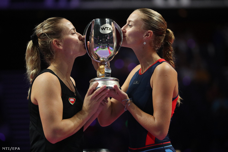 A címvédő Babos Tímea (b) és partnere a francia Kristina Mladenovic megcsókolja a bajnoki trófeát miután 6-4 7-5-re győztek a Barbora Krejcikova Katerina Siniakova alkotta cseh kettős ellen a szingapúri női tenisz-világbajnokság páros versenyének döntőjében 2018. október 28-án.