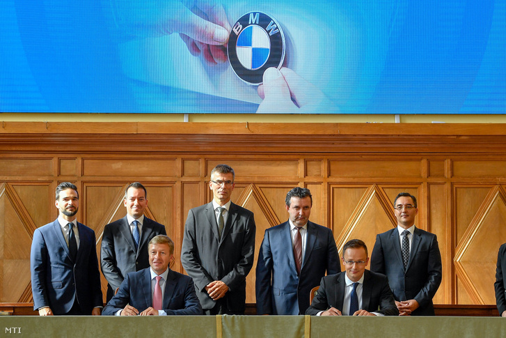 Oliver Zipse, a BMW Group igazgatótanácsának gyártásért felelős tagja (elöl b) és Szijjártó Péter külgazdasági és külügyminiszter (elöl j) a BMW debreceni gyárberuházásának támogatásáról szóló megállapodást a Debreceni Egyetemen 2018. október 12-én. Mögöttük Barcsa Lajos (Fidesz-KDNP) alpolgármester, Ésik Róbert, a Nemzeti Befektetési Ügynökség (HIPA) elnöke, Michele Melchiorre, a BMW gyár debreceni igazgatója, Palkovics László innovációs és technológiai miniszter és Papp László (Fidesz-KDNP) polgármester (b-j)