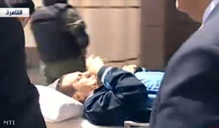 Az al-Arabíja arab nyelvű hírtelevízió adásáról készített felvétel Hoszni MUBARAK volt egyiptomi elnökről, amint egy ágyon érkezik a kairói rendőr-akadémia épületében lévő tárgyalóterembe pere tárgyalásának második napján.