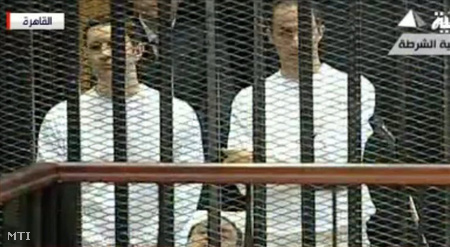 Hoszni Mubarak volt egyiptomi elnök és két fia, Alaal (b) és Gamál (j), a vádlottak számára kijelölt, vasráccsal elkerített területen.