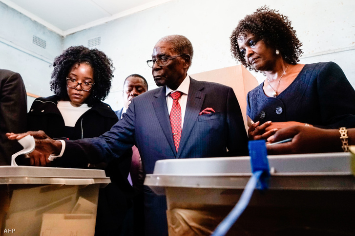 Robert Mugabe (középen) leadja a szavazatát a zimbabwei választásokon 2018. július 30-án, mellette lánya Bona (balra) és felesége Grace látható