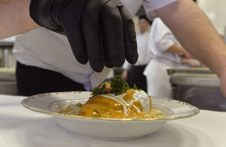 Egy szakács a Lauder csirkét díszíti a Gundel Étterem konyháján 2014. március 6-án.
