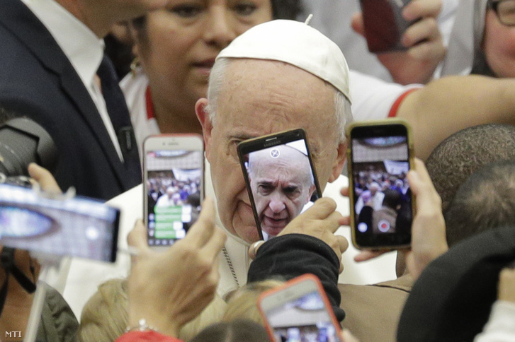 Hívők fotózzák mobiltelefonjaikkal a heti általános audienciájára érkező Ferenc pápát a Vatikán VI. Pál pápa termében 2019. január 9-én