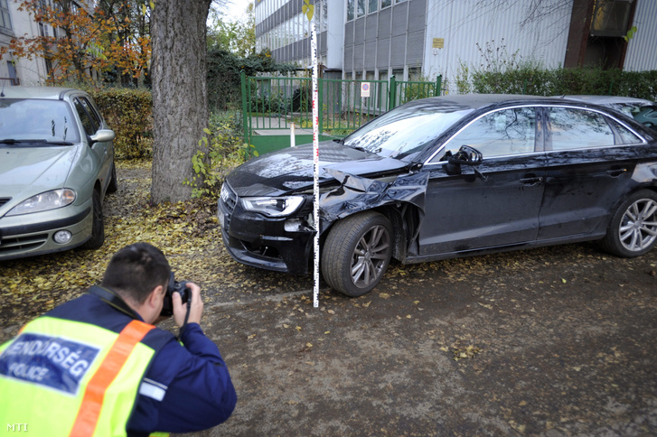 Rendőr helyszínel egy összetört személyautó mellett a XIV. kerületi Nagy Lajos király útján 2016. november 7-én miután az autó eddig tisztázatlan körülmények halálra gázolt egy idõs férfit a Füredi utcában.