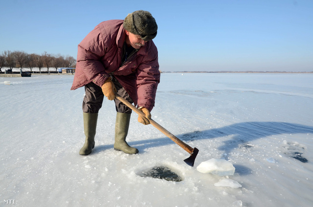 Berta Mihály abádszalóki horgász léket vág a Tisza-tavon. A hideg időben már több mint 10 centiméteres jégtakaró borítja a tavat az abádszalóki öbölben