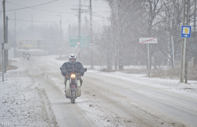 Egy motoros halad behavazott úton Orosháza határában. Békés megyébe -12 Celsius-fokos hideggel és orkán erejű széllel érkezett meg a havazás.