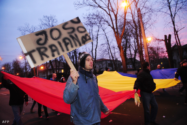 "Le Traiannal (Basescu) és (Emil) Boccal" feliratú táblát hordó tüntető Bukarestben
