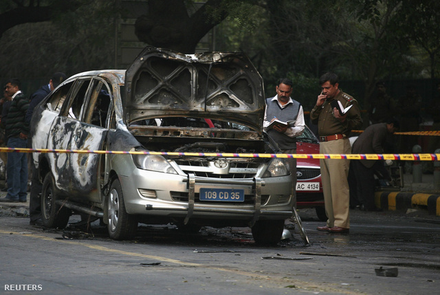 Az Új-Delhi rendőrség helyszínelői vizsgálják a kiégett diplomata kocsit.