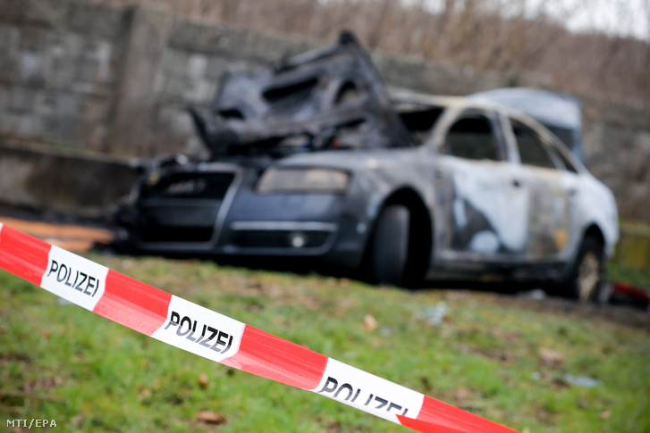 Rendőrségi szalag keríti egy kiégett jármű roncsát a Köln melletti Eil településnél 2019. március 6-án. Az útszélen hagyott járművel rablók menekültek el órákkal korábban a Köln-Bonn nemzetközi repülőtérről egy pénzszállító autó kifosztása után.
