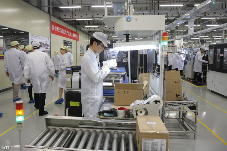 Mobiltelefont gyártó soron dolgozik egy alkalmazott a Huawei kínai távközlési vállalatnak a Kuangtung tartománybeli Tungkuanban működő gyárában 2019. március 7-én.