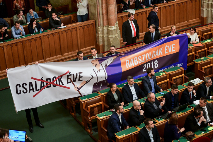 Opposition MPs hold up a sign featuring government slogan "Year of the families" crossed out and "Year of the slaves" on colours reminiscent of advertisements by the government and Fidesz on 12 December 2018.