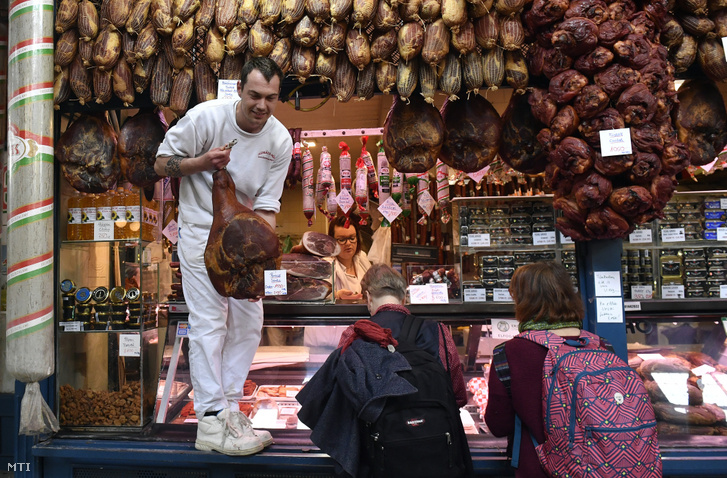 Húsvéti füstölt sonkát vásárolnak egy hús- és hentesárut árusító standnál a budapesti Fővám téri Központi Vásárcsarnokban 2019. április 10-én