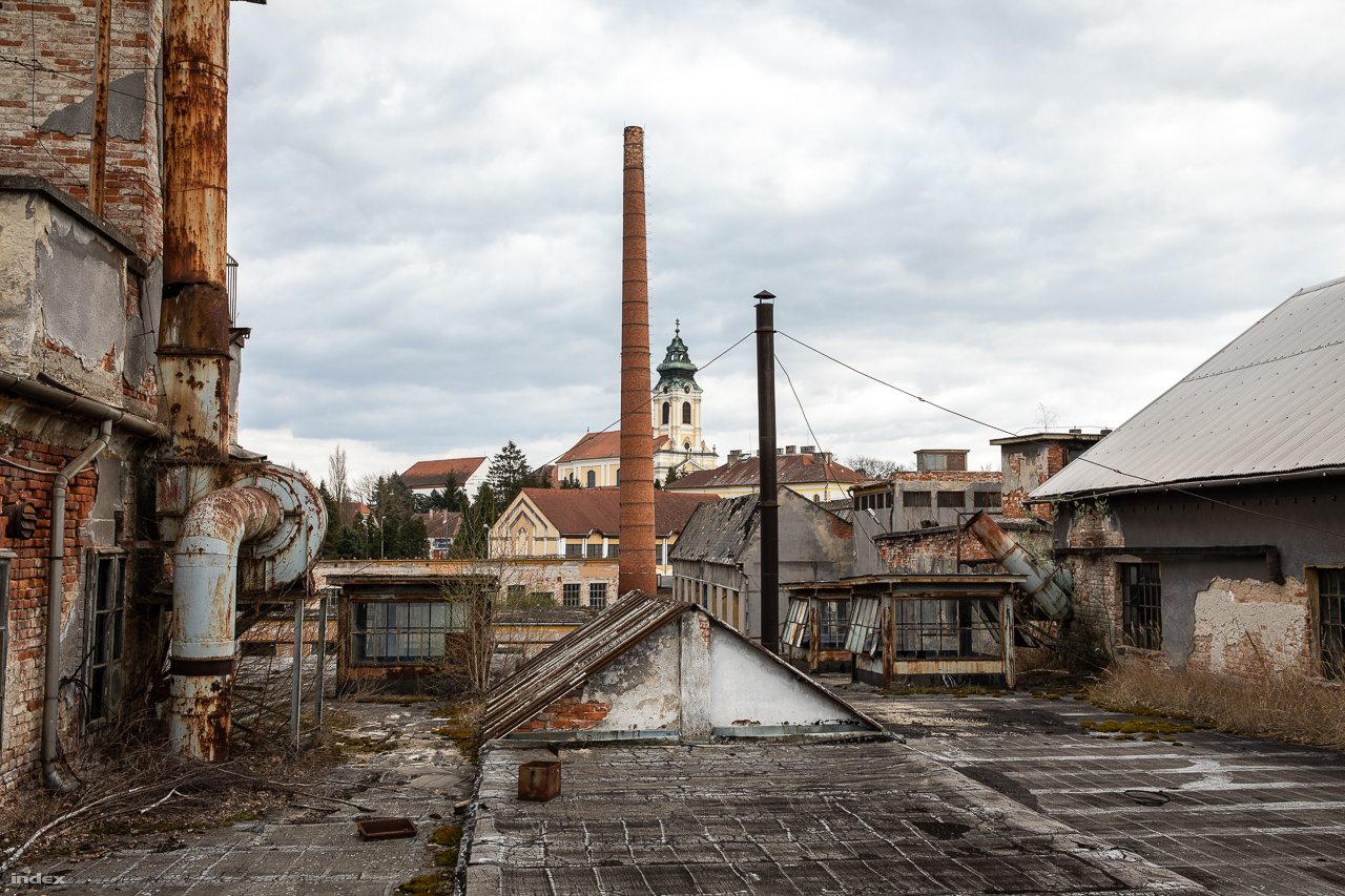 A melegüzem teteje háttérben a gyárkéménnyel és a szentgotthárdi barokk templommal