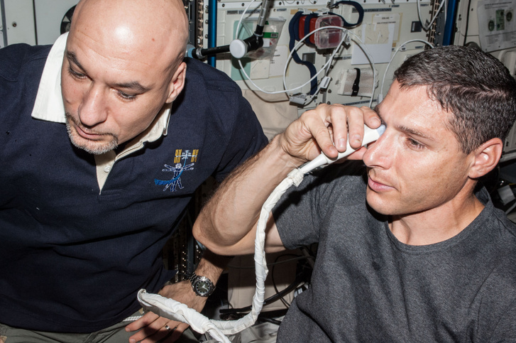 Michael Hopkins amerikai űrhajós (jobbra) szem-ultrahangvizsgálatot végez magán a Nemzetközi Űrállomás fedélzetén