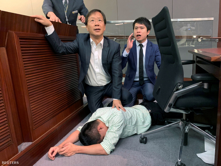 Gary Fan képviselő fekszik a padlón, miután a demokrata és a kormánypárti képviselők összeverekedtek a honkongi parlamentben