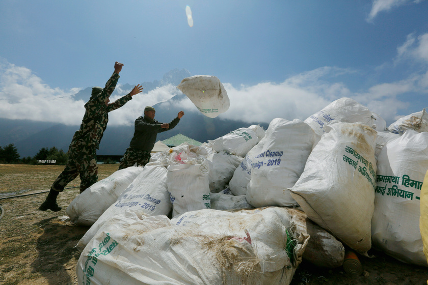 Katonák szeméttel teli zsákokat pakolnak a Mount Everest lábánál, Namche Bazar település közelében 2019. május 27-én.