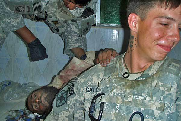 Amerikai katona, vállán egy halott lázadó kezével pózol. Egyike a 18 képnek