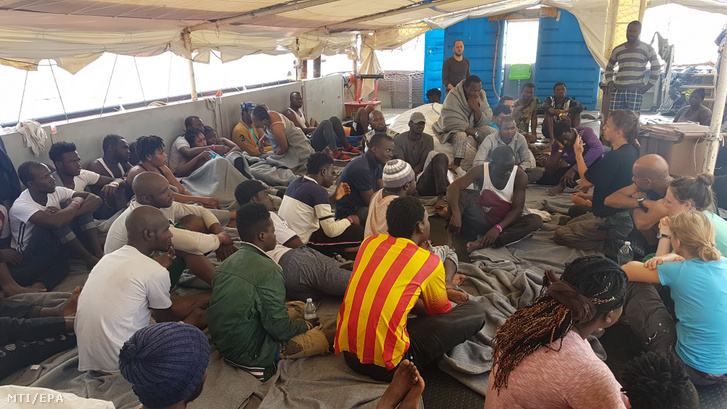 A Sea-Watch civil szervezet 2019. június 15-i felvételele afrikai bevándorlókról a Sea-Watch 3 mentőhajó fedélzetén a Földközi-tengeren. A 43 migránst szállító vízi jármű olasz vizekre ért június 26-án. A kikötési engedély híján 15 napja a nyílt tengeren veszteglő hajó jelenleg Lampedusa partjaitól fél mérföldre várakozik, mert az olasz kormánytól sem kapott engedélyt a kikötésre.