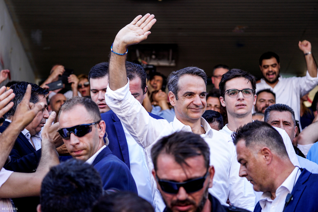 Kiriákosz Micotákisz híveinek integet, miután leadta szavazatát Athénban