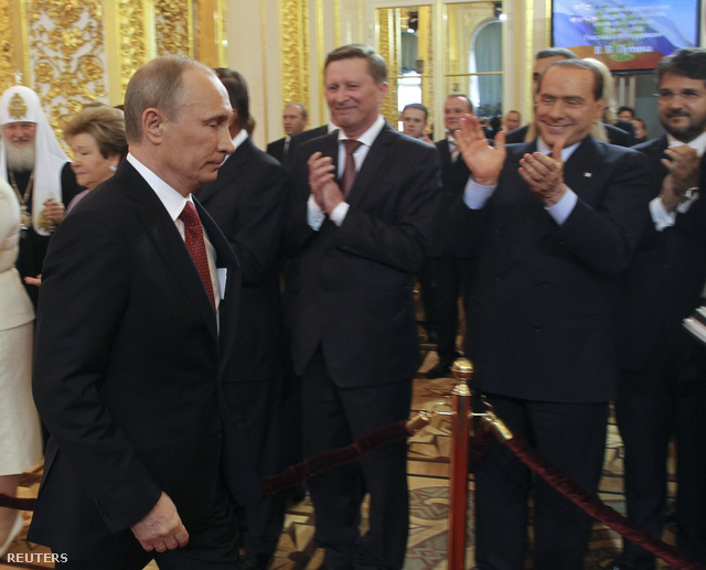 Vlagyimir Putyin sétál az eskütételhez felállított pulpitus felé, a háttérben jobbra Silvio Berlusconi, volt olasz miniszterelnök tapsol