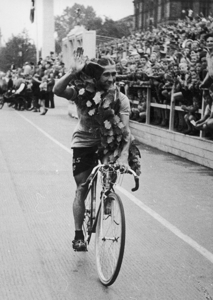 A verseny győztese, a német kerékpáros, Georg Umbenhauer koszorúval a szurkolók előtt