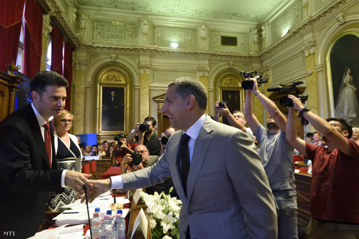 Márki-Zay Péter (független) polgármester (b) és Lázár János, a térség fideszes országgyűlési képviselője kezet fog a hódmezővásárhelyi közgyűlés ülésén 2018. május 29-én.