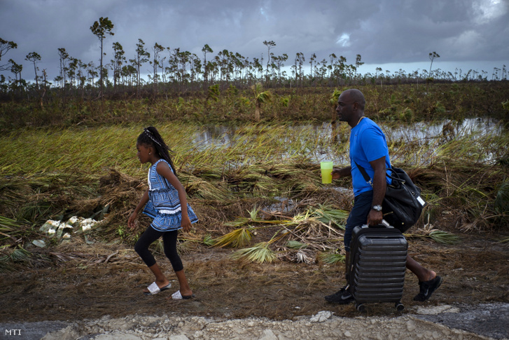 Apa és lánya megy a Dorian hurrikán által letarolt területen a Bahama-szigeteken fekvõ High Rock közelében 2019. szeptember 5-én.