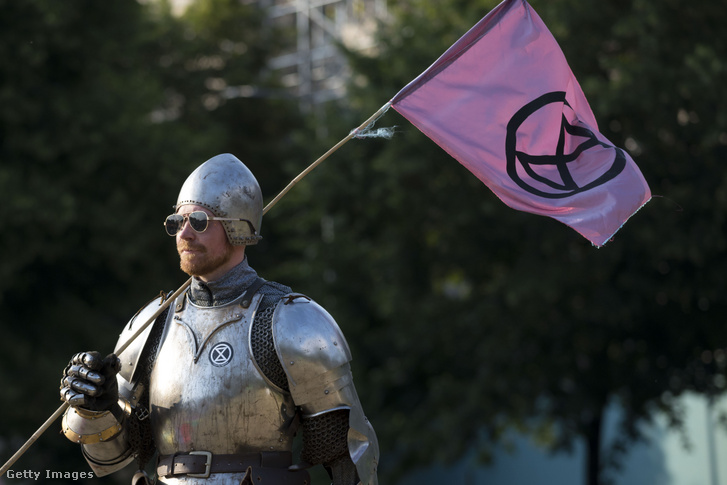 An activist of Extinction Rebellion standing clad in armor at a demonstration for climate action called "Project Mushroom" in Cardiff.