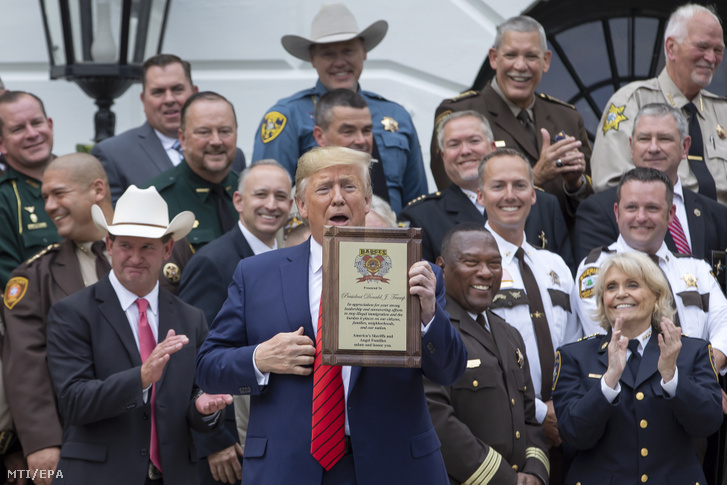 Donald Trump amerikai elnök (k) átveszi az illegális bevándorlás megállításáért tett erőfeszítéseiért az America's Sheriffs és az Angel Families szervezet kitüntetését a washingtoni Fehér Ház kertjében 2019. szeptember 26-án.