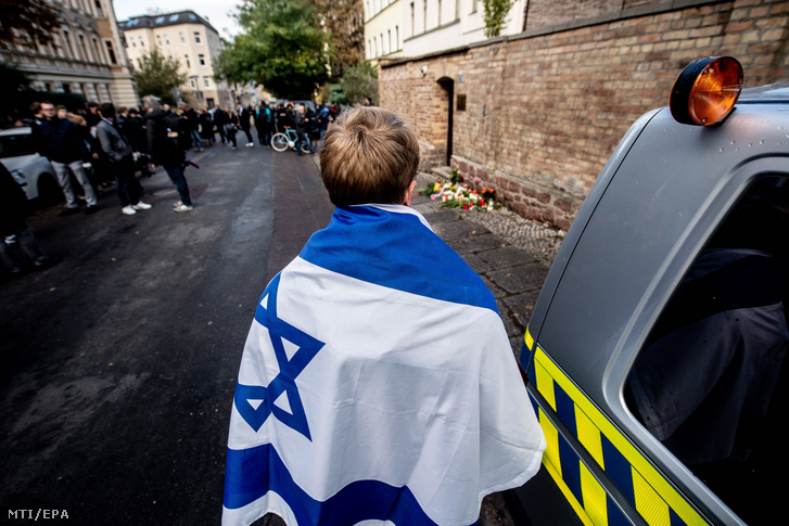 Izraeli zászlóba burkolózott férfi a hallei zsinagógánál, a németországi városban elkövetett lövöldözés utáni napon, 2019. október 10-én.