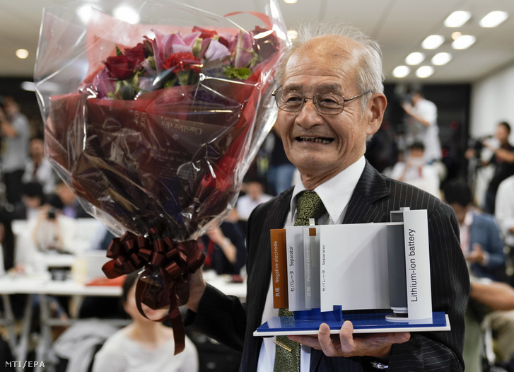 Josino Akira japán tudós virágcsokorral és az általa kifejlesztett lítiumion-akkumulátor makettjével a kezében tokiói sajtótájékoztatója végén 2019. október 9-én