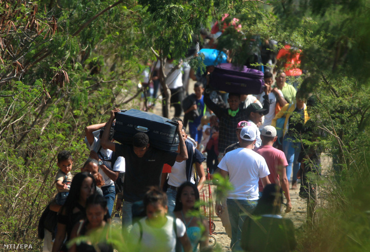 A kolumbiai Cúcutába tartó venezuelai emberek bõröndjeikkel távoznak az országból a lezárt Simón Bolívar híd közelében lévő zöldhatáron 2019. február 25-én.