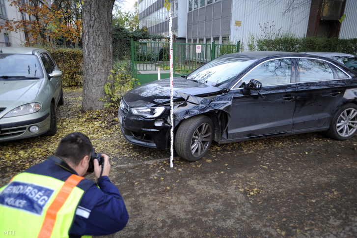 Rendőr helyszínel egy összetört személyautó mellett a XIV. kerületi Nagy Lajos király útján 2016. november 7-én, miután az autó eddig tisztázatlan körülmények halálra gázolt egy idős férfit a Füredi utcában