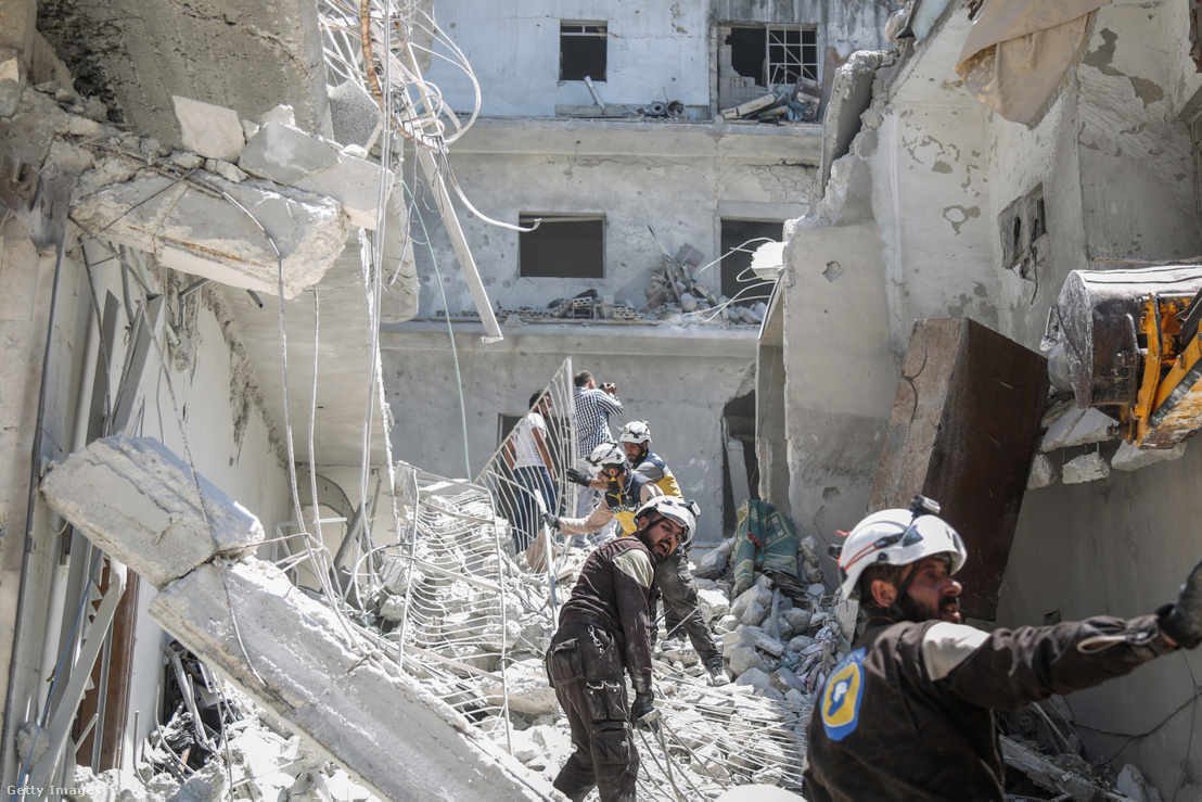 Fehérsisakosok, azaz a Szíriai Polgári Védelem emberei egy idlibi légitámagás után keresnek túlélőket 2019. július 27-én