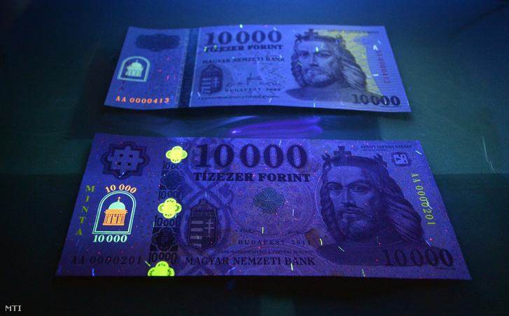 Az új tízezer forintos bankjegy mintája látható UV-fényben egy tárlóban a korábbi bankjegy előtt a Magyar Nemzeti Bank Milyen lesz a magyar készpénz? című sajtótájékoztatóján az MNB budapesti székházában 2014. szeptember 1-én.