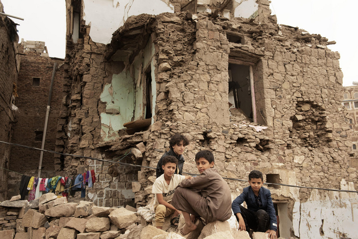 Jemeni gyerekek egy légitámadásban lerombolt ház előtt, 2019. június 20-án, Szanaa-ban