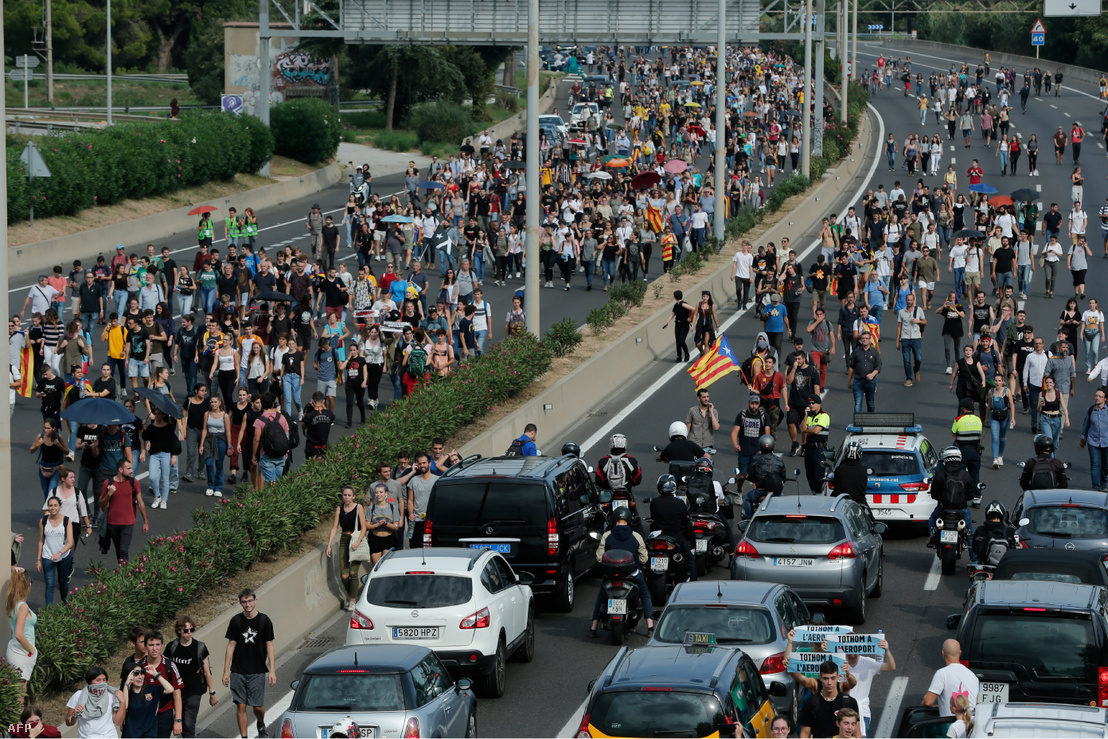 People walk on the highway towards El Prat airport in Barcelona on October 14 2019 as thousands of angry protesters took to the streets after Spain's Supreme Court sentenced nine Catalan separatist leaders to between nine and 13 years in jail for sedition over the failed 2017 independence bid.
