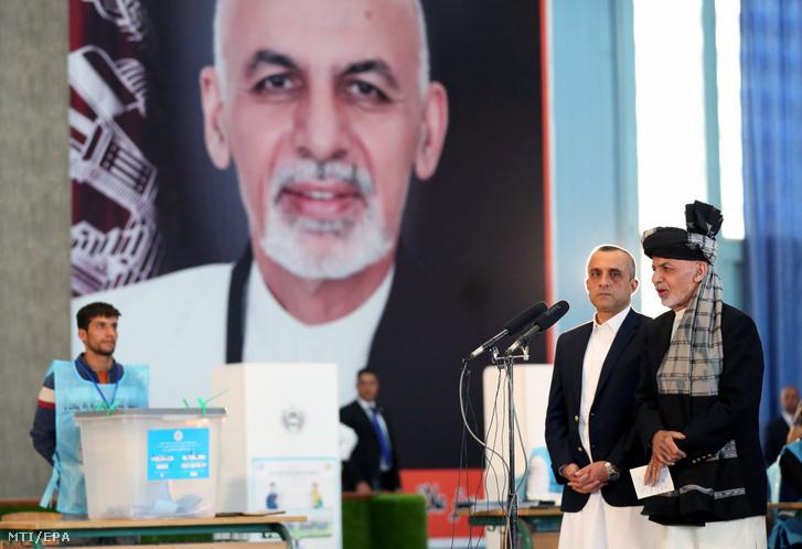 A tisségéért újra induló Asraf Gáni hivatalban lévõ államfõ (j) sajtótájékoztatót tart az őt ábrázoló óriásplakát előtt Amrulla Száleh alelnök társaságában miután voksoltak az afganisztáni elnökválasztáson Kabulban 2019. szeptember 28-án
