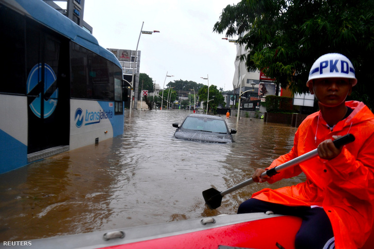 Biztonsági erők felfújható csónaokt használva közlekednek a kiáradt folyón Jakarta Kemand körzetében 2020. január 1-én