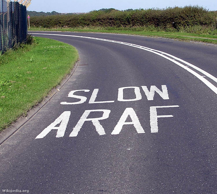 Angolul és walesiül is lassításra intő aszfaltfelirat Walesben