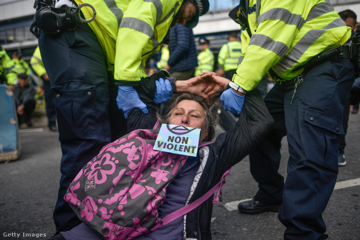 Az Extinction Rebellion egyik tüntetőjét vonszolják a rendőrök a londoni reptérnél tartott négynapos tiltakozáskor, 2019. október 10-én.
