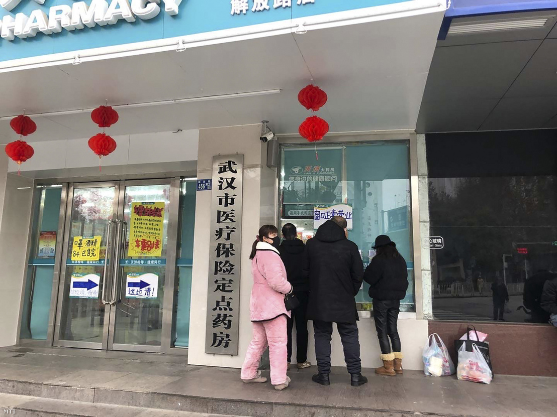 Vuhan egyik gyógyszertárának ablaka előtt várakoznak vásárlók 2020. január 27-én.